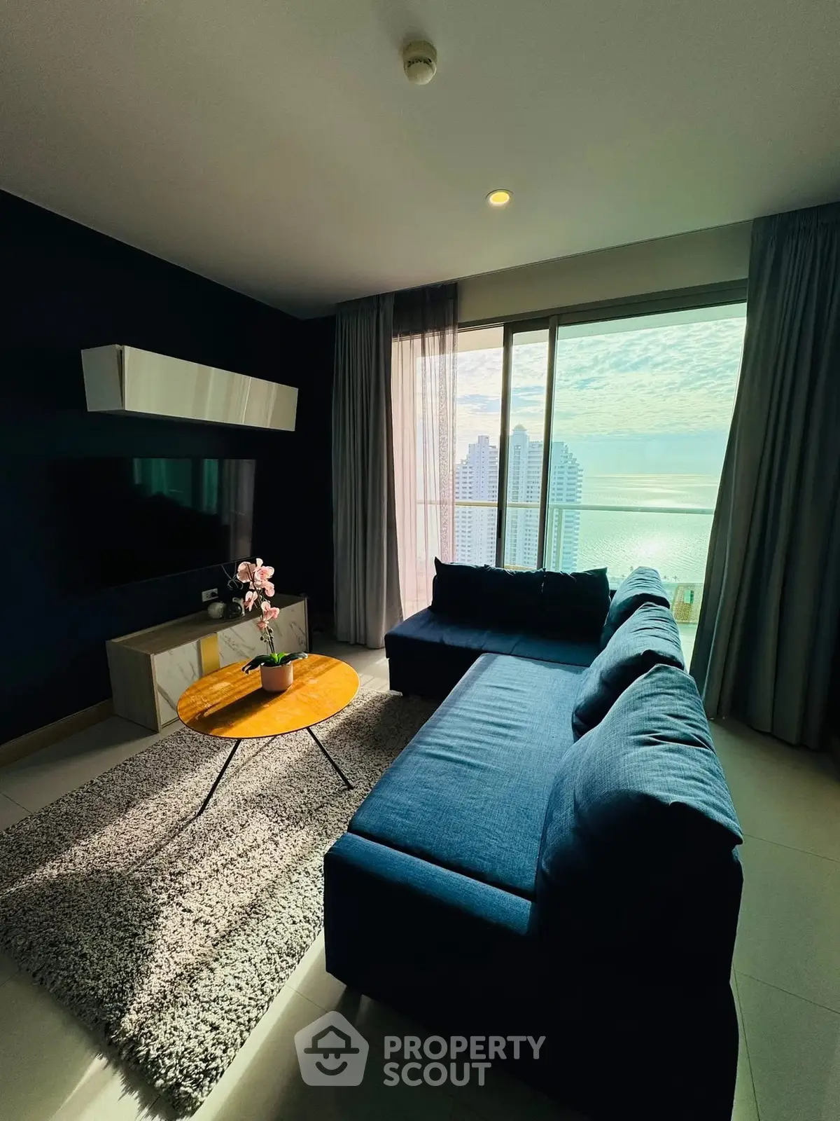 Stunning living room with ocean view, modern furniture, and natural light in luxury apartment.