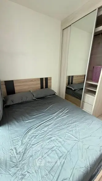 Cozy bedroom with mirrored wardrobe and stylish headboard in modern apartment.