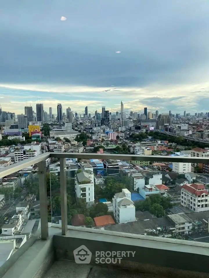 Stunning cityscape view from a high-rise balcony, showcasing urban skyline and vibrant city life.