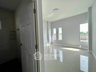 Bright and airy room with large windows and glossy tiled floor, perfect for modern living.
