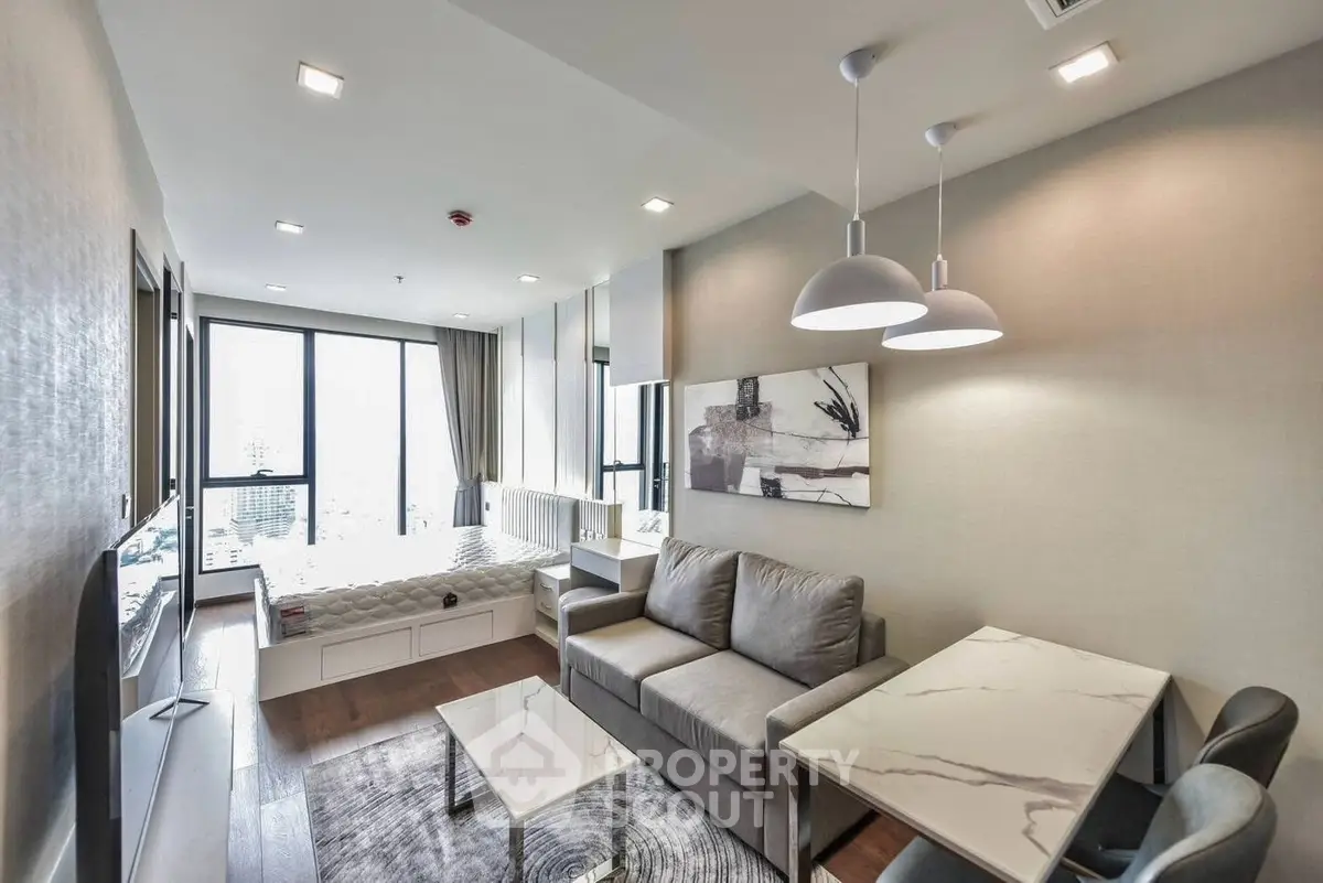 Modern living room with stylish decor and large windows offering city views