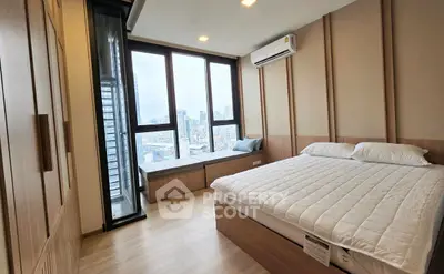 Modern bedroom with city view and large windows, featuring a cozy bed and stylish decor.