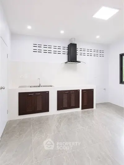 Modern kitchen with sleek cabinetry and tiled flooring in a bright, minimalist design.