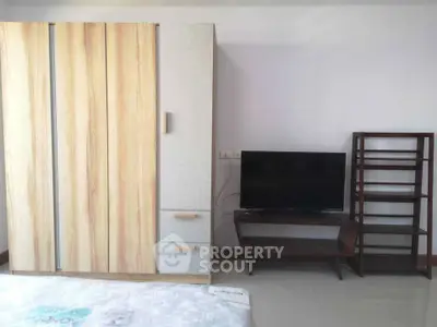 Modern bedroom with sleek wardrobe and TV setup, perfect for stylish living.