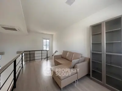 Modern loft space with sleek sofa and glass cabinet, perfect for stylish living.