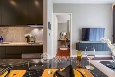 Modern open-layout kitchen and living room with elegant decor and stylish furnishings.
