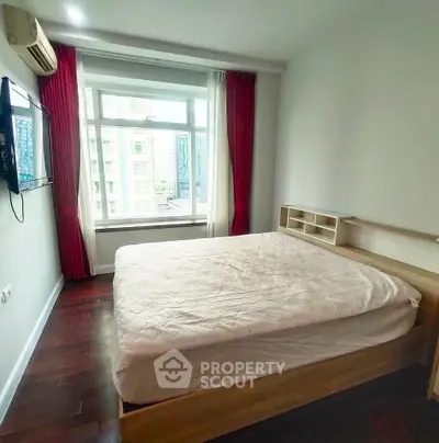 Cozy bedroom with large window and red curtains in modern apartment