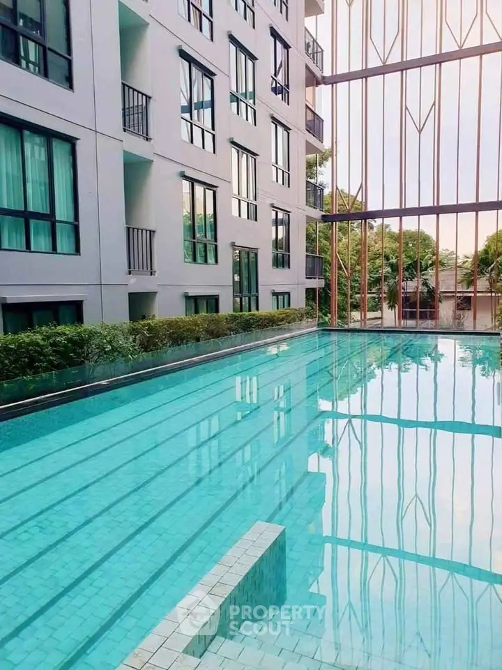 Luxurious apartment complex with a pristine swimming pool and modern architecture.