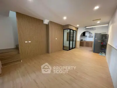 Spacious modern living room with wooden flooring and open kitchen layout