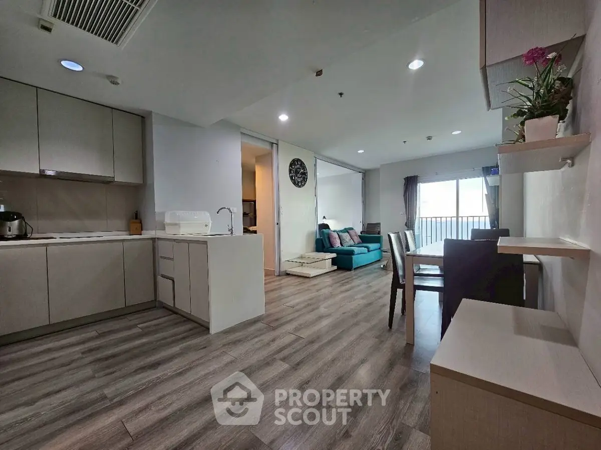 Spacious open-plan living area with modern kitchen and cozy seating, perfect for entertaining.