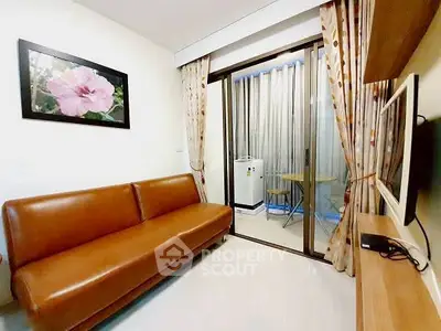 Cozy living room with brown leather sofa and sliding glass door to balcony