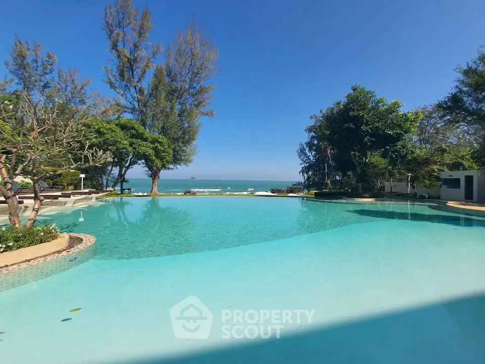 Luxurious beachfront pool with stunning ocean view and lush greenery