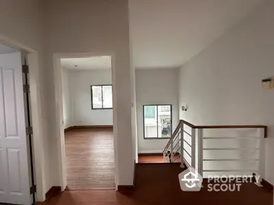 Spacious interior hallway with wooden flooring and modern railing design