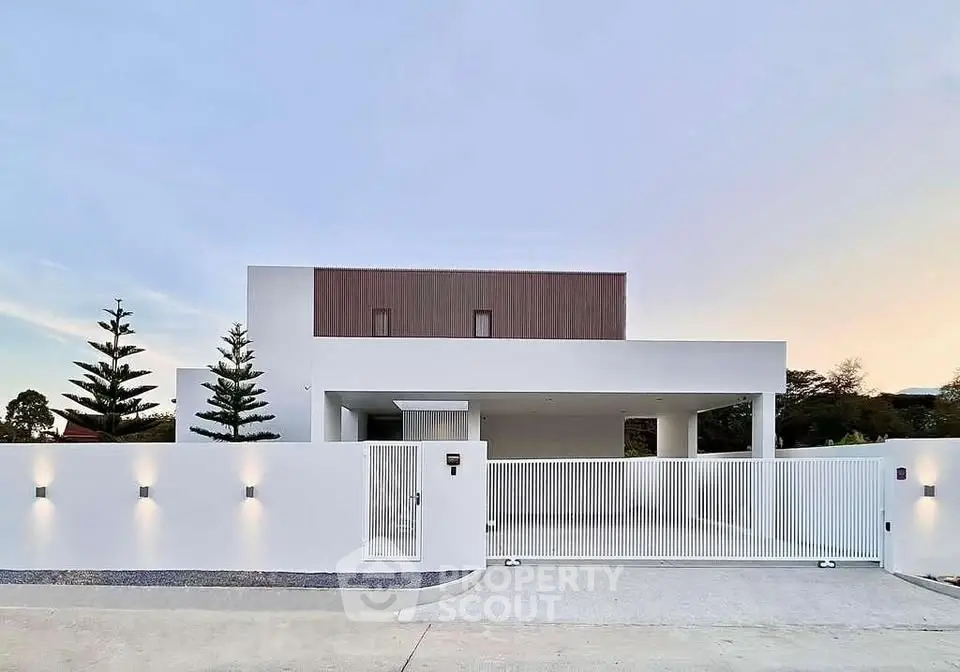 Modern minimalist white house with sleek design and gated entrance