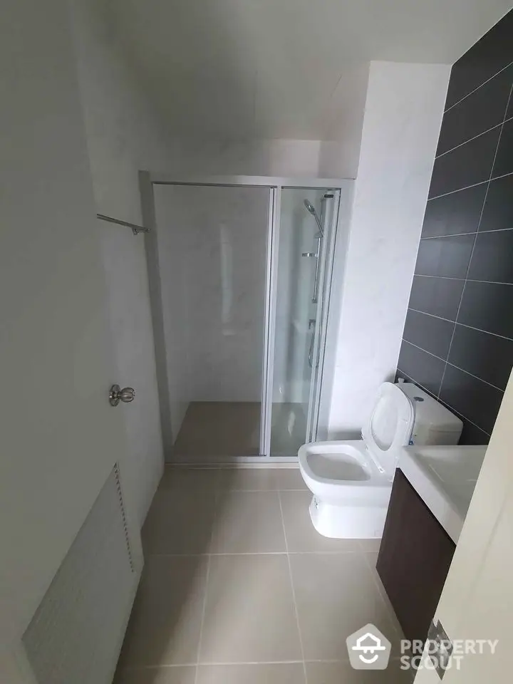 Modern bathroom with sleek shower and contemporary fixtures in a stylish apartment.