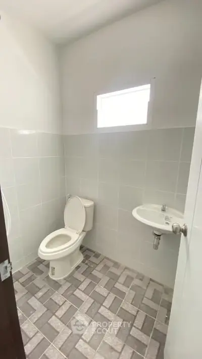 Minimalist bathroom with white tiles and small window