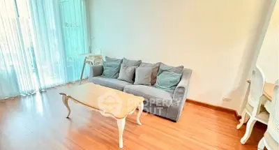 Bright living room with elegant sofa and wooden flooring, perfect for relaxation.