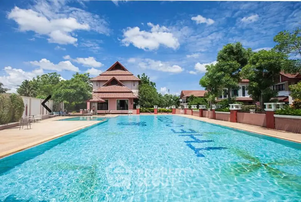 Luxurious residential pool with clear blue water and elegant architecture under a bright sky.