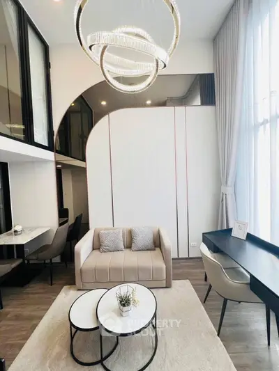 Modern living room with high ceiling and elegant chandelier in luxury apartment.