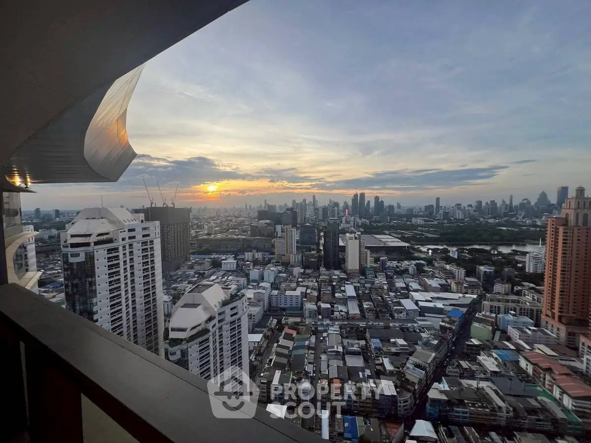 Stunning cityscape view from a high-rise balcony at sunset, showcasing urban skyline.