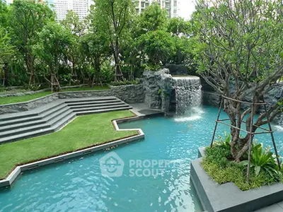 Luxurious garden pool with waterfall feature in upscale property