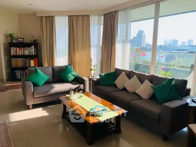 Spacious living room with modern sofas and city view, perfect for relaxation and entertaining.