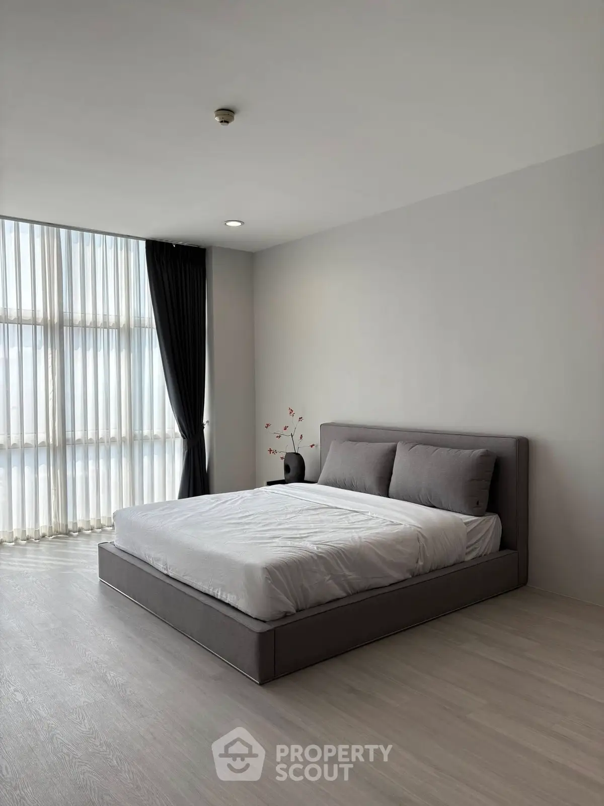 Spacious modern bedroom with large window and elegant decor