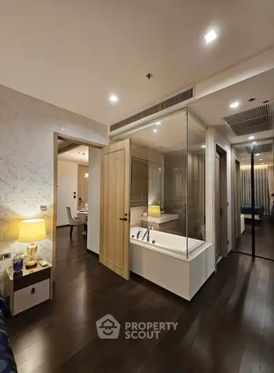 Modern apartment interior with glass-enclosed bathtub and elegant lighting