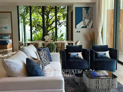 Luxurious living room with elegant decor and garden view, featuring plush seating and stylish dining area.