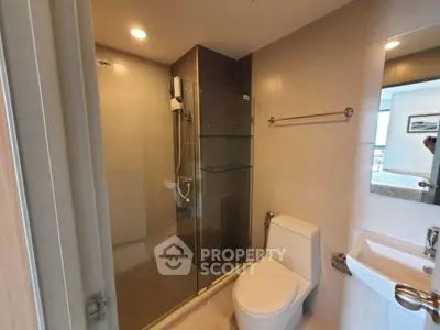 Modern bathroom with glass shower enclosure and sleek fixtures