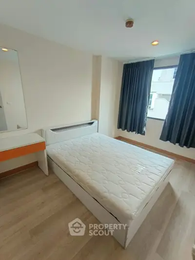 Cozy bedroom with natural light and modern furnishings in a stylish apartment.