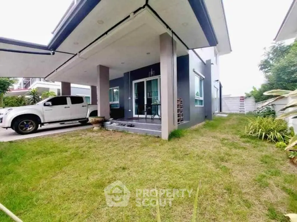 Modern house exterior with carport and lush green lawn