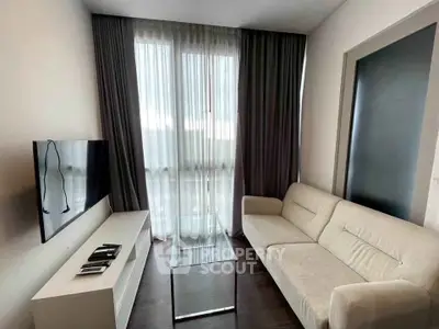 Modern living room with sleek furniture and large window for natural light.
