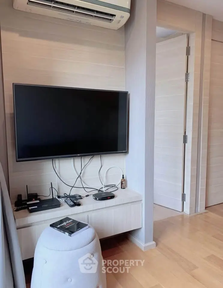 Modern living room with wall-mounted TV and sleek air conditioning unit.