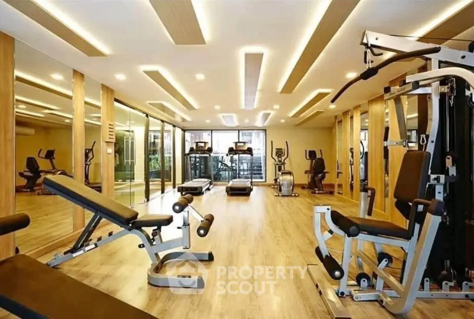 Luxurious gym with modern equipment and elegant lighting in a high-end residential building.