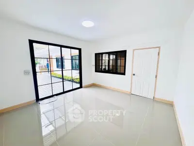 Bright and spacious room with large windows and glossy tiled floor