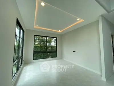 Modern empty room with large windows and recessed lighting