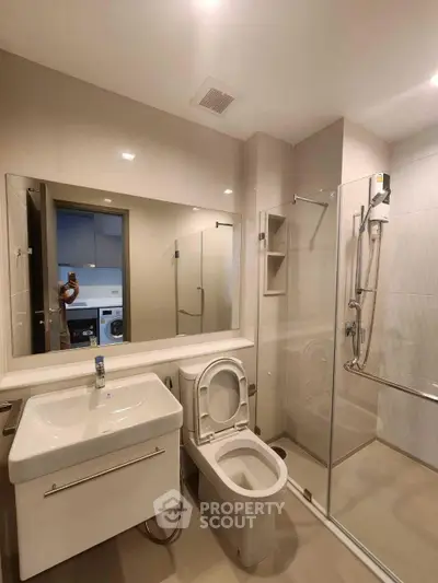 Modern bathroom with glass shower and sleek fixtures in a contemporary apartment.