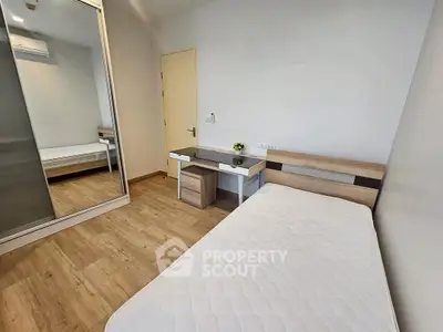 Modern minimalist bedroom with sleek furniture and wooden flooring