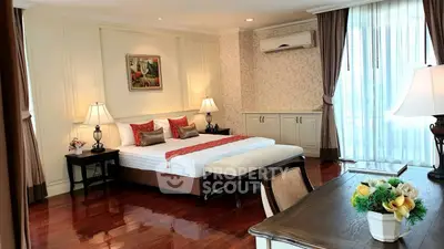 Luxurious bedroom with elegant decor and large windows offering natural light.