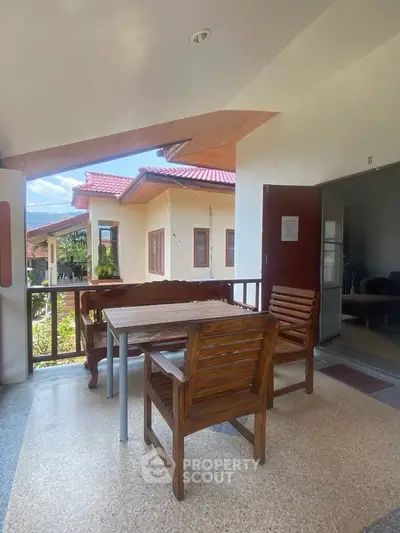 Charming outdoor seating area with wooden furniture and scenic view, perfect for relaxation.