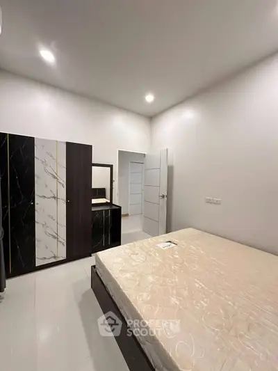 Modern bedroom with sleek wardrobe and minimalistic design, perfect for urban living.