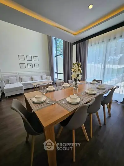 Elegant dining area with modern decor and large windows in a stylish home.