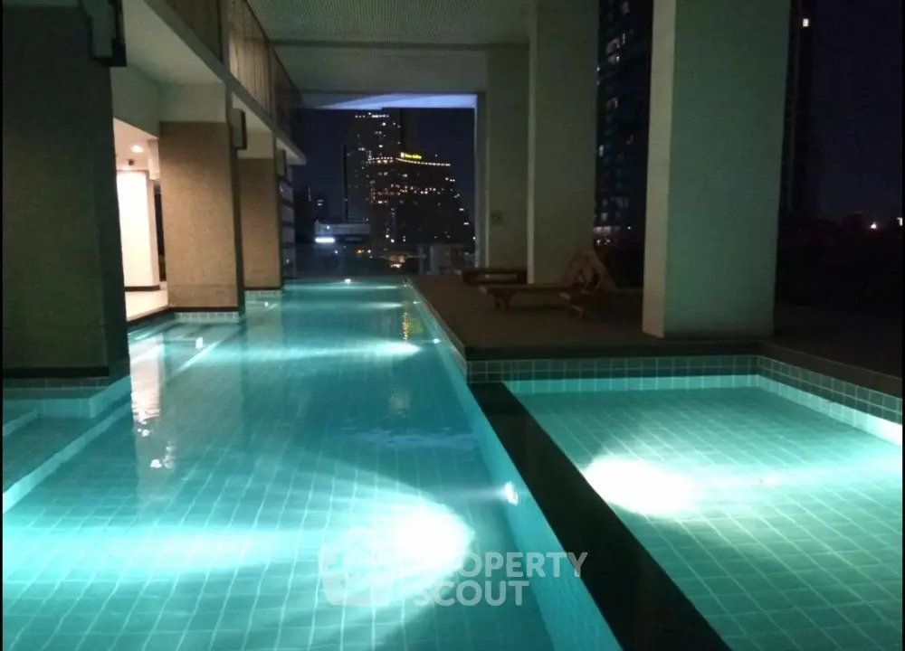 Luxurious rooftop pool with stunning city view at night, perfect for relaxation and entertainment.
