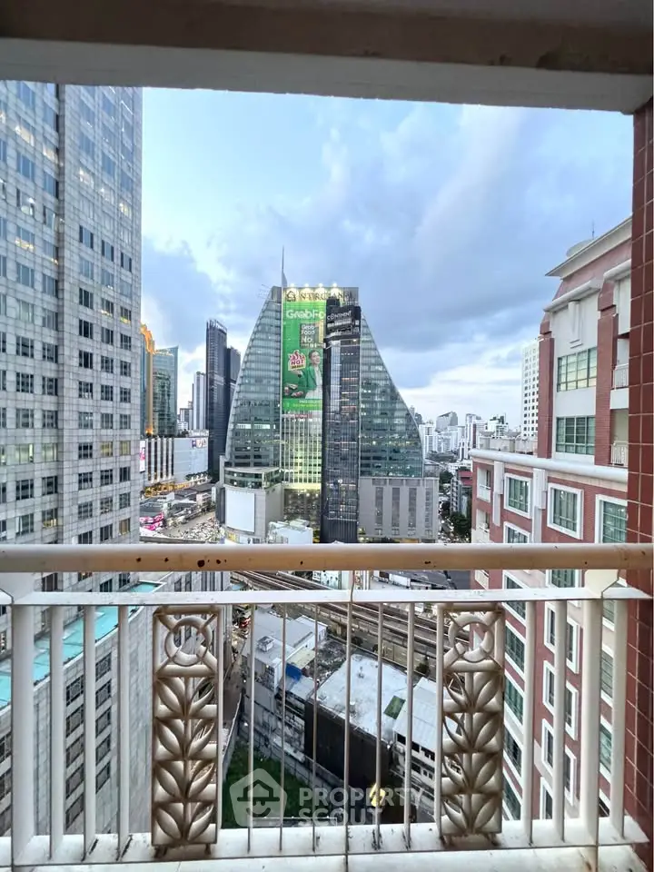 Stunning cityscape view from a high-rise balcony overlooking modern skyscrapers and bustling urban life.