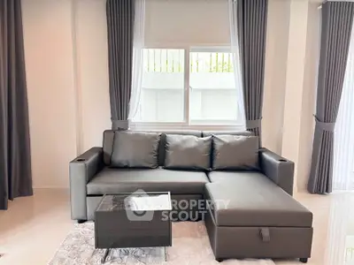 Modern living room with sleek gray sofa and elegant curtains