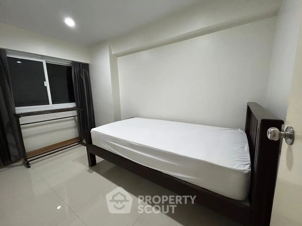 Minimalist bedroom with single bed and window view