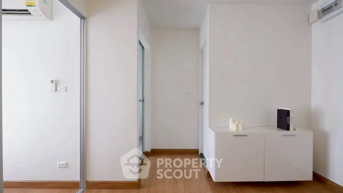 Modern minimalist interior with sleek white cabinetry and wooden flooring, perfect for contemporary living.