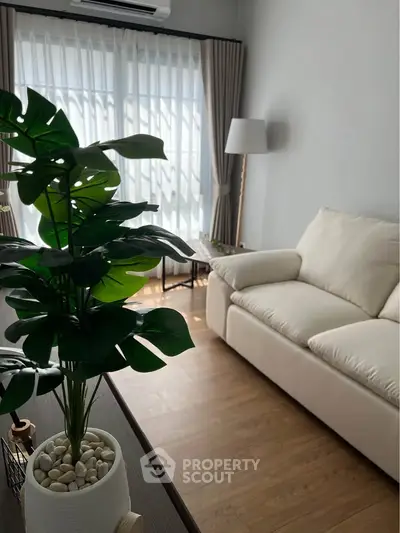 Bright and cozy living room with white sofa and large window