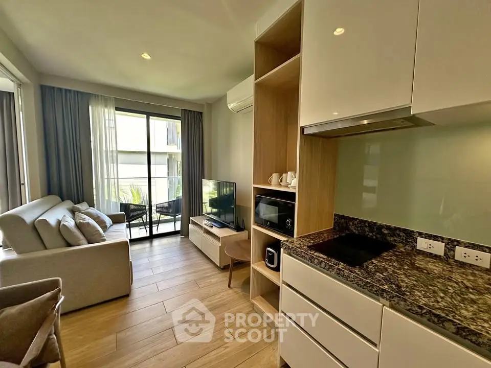 Modern living room with open kitchen and balcony view in stylish apartment